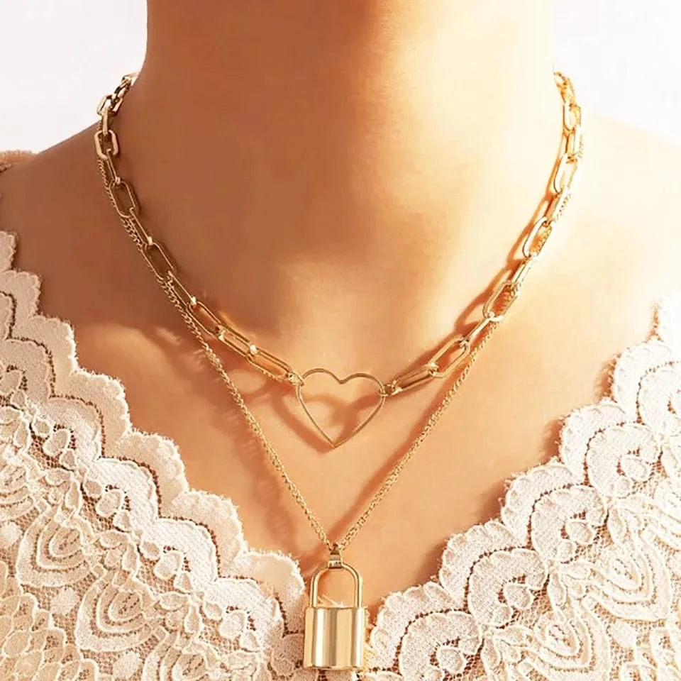  A woman wearing a gold heart necklace, radiating confidence and elegance.