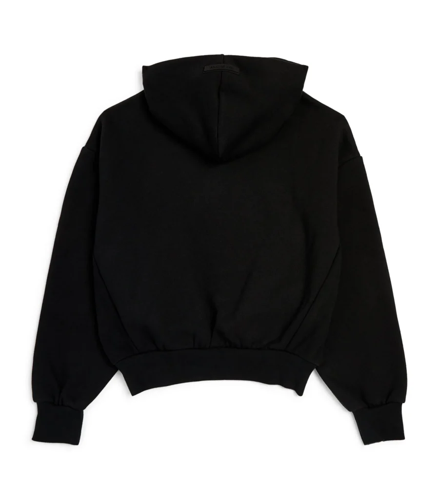 A laid-back black essentials hoodie draped over a chair, symbolizing casual elegance and everyday wearability.